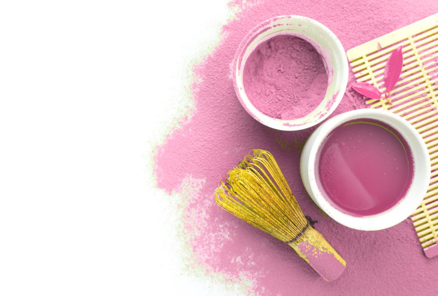 A pink matcha set: bowl, whisk and a heap of pink matcha powder, seen from above