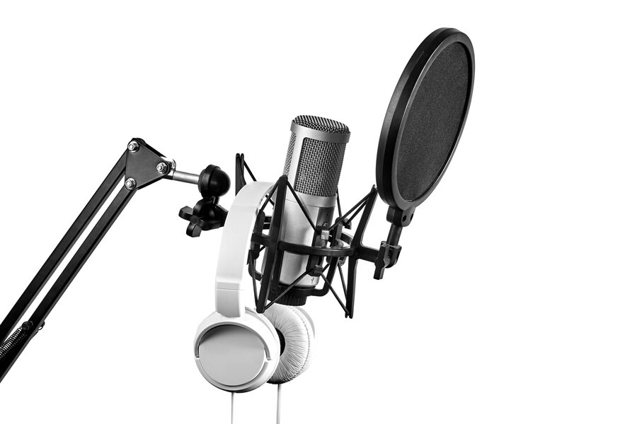 A studio condenser microphone with pop filter on a boom arm