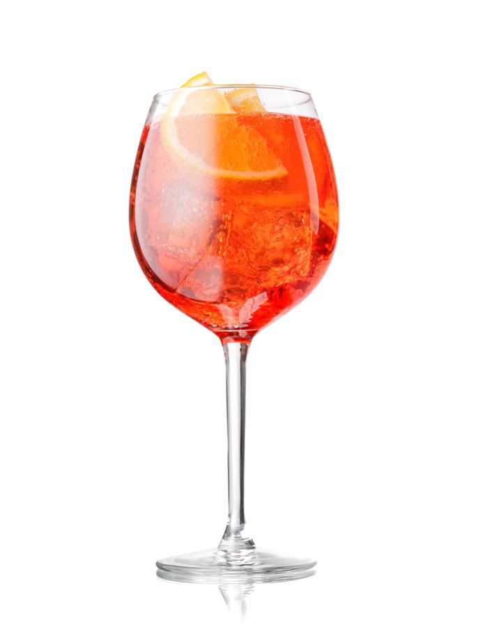 A large wine glass filled with an orange spritz cocktail